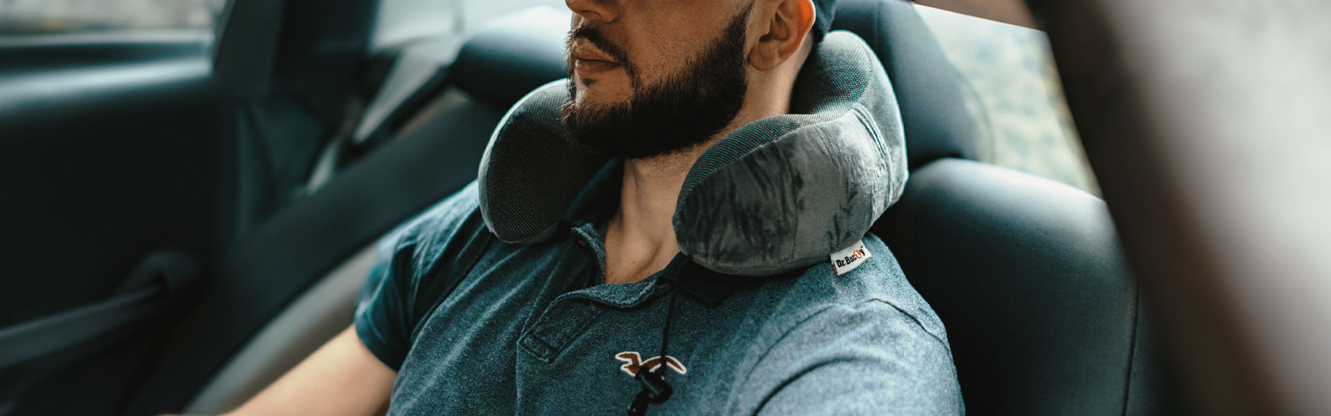 Poduszka podóżna w kolorze szarym na szyji mężczyzny